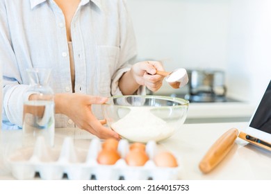 Add flour to a large bowl, close-up of hands of housewife cooking in the kitchen - stock photo