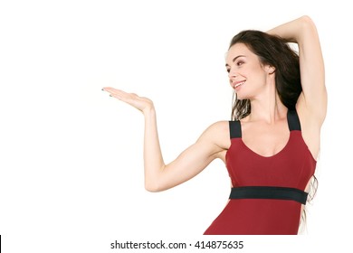 Add something here. Half length studio shot of a beautiful young fitness woman holding copyspace on her hand smiling cheerfully 