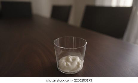 add yogut in tumbler glass on wood table, wide photo