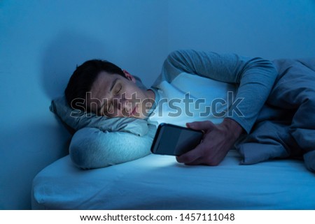 Similar – Image, Stock Photo Phone addiction. Man lying in bed with smartphone