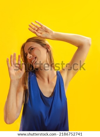 Addiction. Young pretty girl, student leaned against transparent glass isolated on yellow color background. Close-up. Mental health, emotions concept