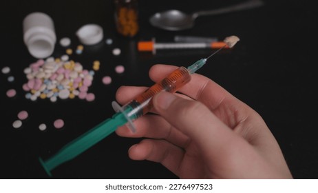 addict's table pills and injection on the black table - Shutterstock ID 2276497523