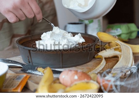 Adding generous portion of whipped cream to chocolate dessert during preparation process
