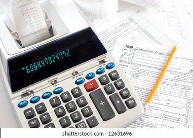 An Adding Machine Or Calculator With Adding Machine Tape Or Paper And Tax Forms