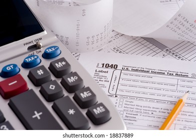 An Adding Machine Or Calculator With Adding Machine Tape Or Paper And Tax Forms