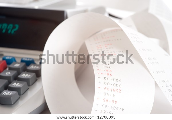 An adding machine or calculator with adding\
machine tape or paper.