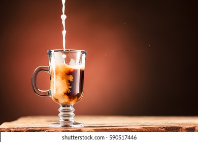 Adding milk to a cup of coffee. Stock Photo
