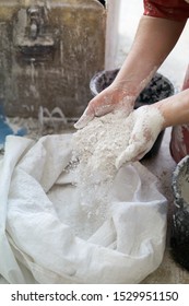 Adding The Plaster Powder To The Water In A Mixing Container By Sprinkling Or Sifting The Powder Over The Water. Preparing Plaster Mix With Sculptor Bare Hands. Basic, Essential Sculpting Supplies.