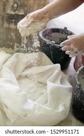 Adding The Plaster Powder To The Water In A Mixing Container By Sprinkling Or Sifting The Powder Over The Water. Preparing Plaster Mix With Sculptor Bare Hands. Basic, Essential Sculpting Supplies.