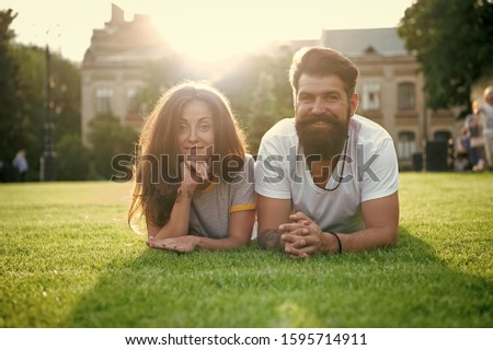 Adding some romance. Holiday romance of bearded man and sexy woman. Couple in love relaxing on green grass on sunny summer outdoor. Feeling romance. Love and romance.