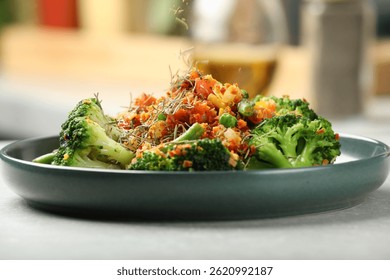 Adding spices to dish at light table indoors, closeup