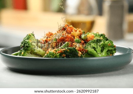 Adding spices to dish at light table indoors, closeup