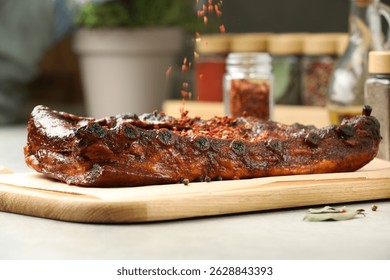 Adding spices to tasty dish at table, closeup