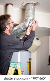 Adding Tape To Home Duct Work Standing On A Ladder