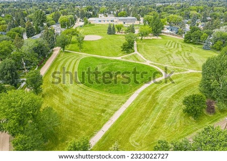 Similar – A tranquil aerial view of a lush golf course fairway, bathed in the warm glow of sunset. Ideal for themes of relaxation, nature, and sports, this image captures the peaceful beauty of the golfing experience.