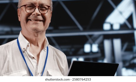 Adept IT professional navigating network of servers in industrial workspace. Engineer with laptop in hand ensuring seamless operations, doing optimizations and maintenance in data center