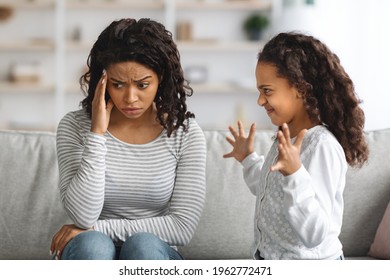 ADHD, Misbehaving In Children Concept. African American Hyperactive Kid Looking For Attention From Her Tired Mother, Home Interior. Naughty Black Daughter Screaming Towards Her Mom, Home Interior