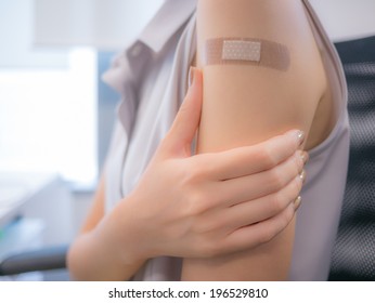 Adhesive Bandage On A Female Arm After Vaccination