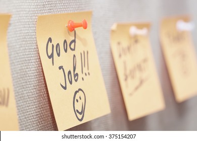 Adhesive note with Good Job text on a cork bulletin board