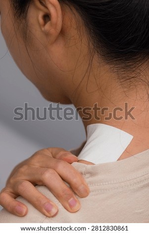Adhesive patch applied to the back of the neck