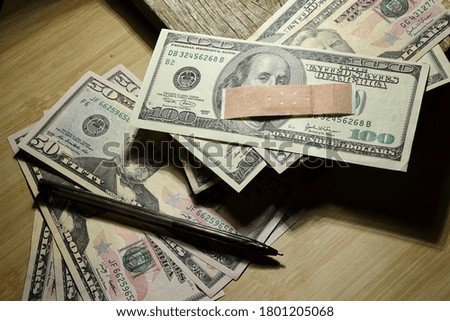 Adhesive plaster on a stack of 50 and 100 bills

