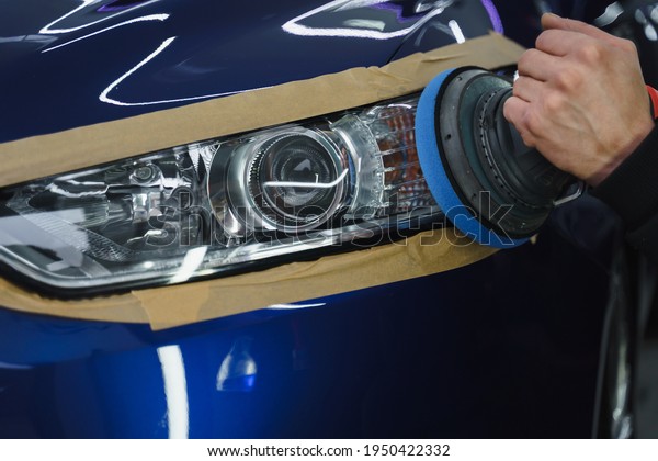 Adhesive tape on car headlights. Headlight
polishing. Detailing car
outside.
