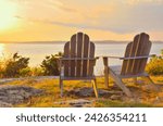 Adirondack chairs on cliff overlooking the water Narragansett Bay at sunset, late summer, early fall, golden hour Newport, Rhode Island. Romantic scenic New England seaside getaway on the east coast.