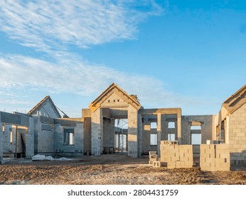 Adjoining concrete shells of an upscale, hurricane-resistant house under construction in a suburban residential development in southwest Florida. Street view, early morning.