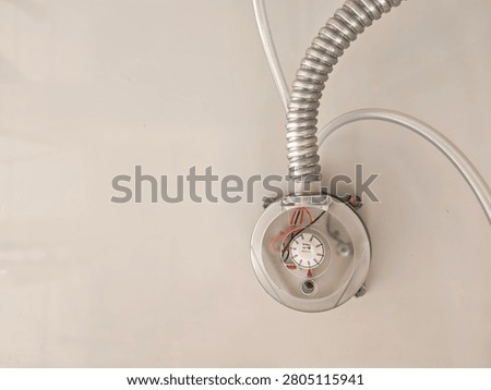 Adjustable differential pressure switch measuring in Pascals, mounted on a wall with flexible metallic conduit and pneumatic tubes for air filter monitoring in an HVAC system.