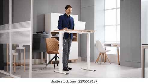 Adjustable Height Desk Stand In Office Using Computer - Powered by Shutterstock