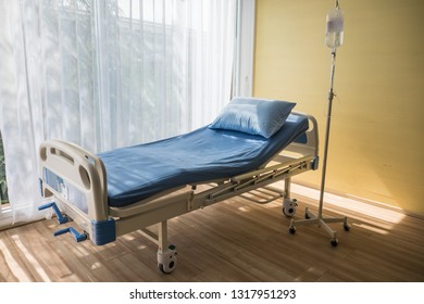 Adjustable Patient Bed In Hospital Room With Warm Light.