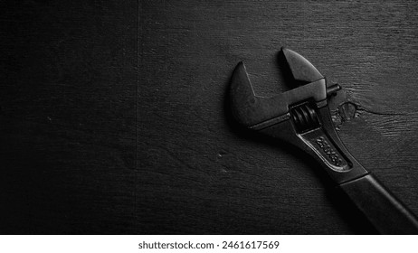 adjustable spanner (monkey spanner). Repair tools. On a black background. Concept of repair or adjustment.