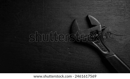 adjustable spanner (monkey spanner). Repair tools. On a black background. Concept of repair or adjustment.
