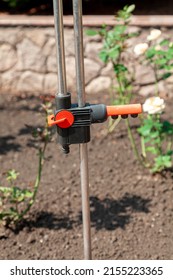 adjustable valve of the irrigation system fixed on vertical metal rails stands in the garden