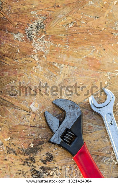 adjustable\
wrench, spanner tools on old wooden\
table