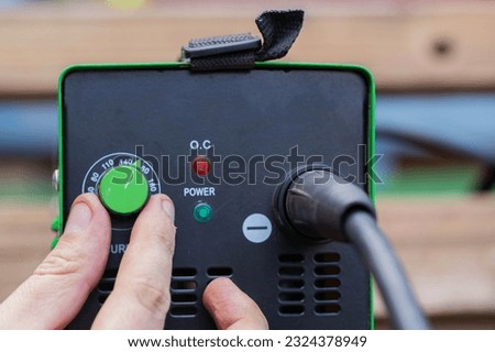 Adjusting the current strength on a modern welding machine. Welding arc.