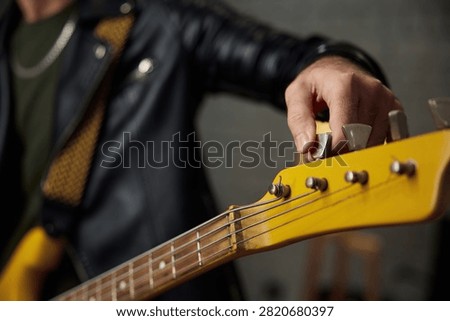 Adjusting headstock before setup. Tuning bass guitar headstock manually