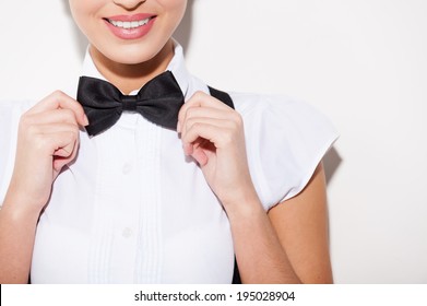 Adjusting Her Bow Tie. Close-up Of Young Short Hair Woman In White Shirt And Suspenders Adjusting Her Bow Tie 