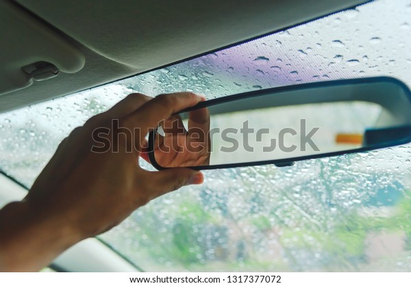 Adjusting the rearview mirror in the car to make the\
rear view better on heavy rain days, Rearview mirror adjustment in\
cars, Washing the\
car.