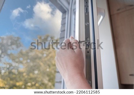 adjusting the white plastic window. a worker uses a hexagon to repair a window. 