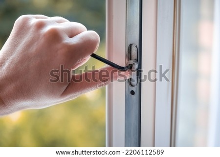 adjusting the white plastic window. a worker uses a hexagon to repair a window. 