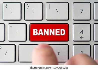 admin bans the user. The red button on the keyboard of a notebook with the inscription of banned. The concept of blocking in the Internet