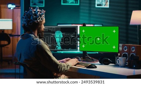 IT admin coding and using EEG headset to upload brain into mockup computer, gaining immortality. Neuroscientist engineering transhumanism experiment on isolated screen PC, camera A