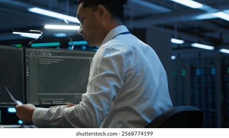 Admin in data center maintaining accurate documentation of infrastructure, configurations and procedures, generating reports. Server room employee doing workspace disaster recovery planning, camera A