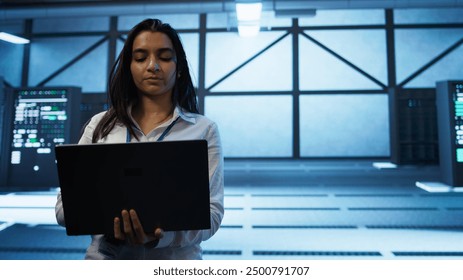 Admin in data center managing servers, operating systems and software programs. Tracking shot of woman in server hub ensuring networks are secure, up to date, and functioning properly, camera B
