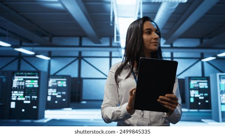 Admin in data center monitoring security threats with tablet, implementing cybersecurity measures. Specialist using device, ensuring compliance with regulations to protect data center gear, camera B - Powered by Shutterstock