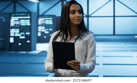 Admin in data center monitoring security threats with tablet, implementing cybersecurity measures. Specialist using device, ensuring compliance with regulations to protect data center gear, camera A
