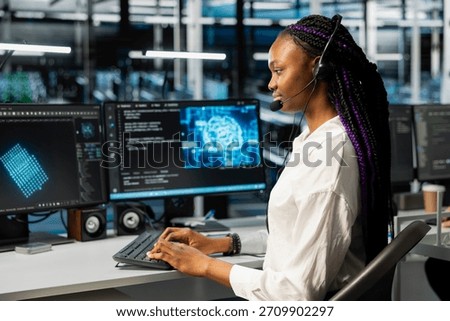Admin in data center provides user technical support, fixing network errors affecting operations. Server hub worker talking in headset mic, managing live support calls, assisting clients