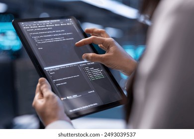 Admin in data center using diagnostic tools and system monitoring software on tablet device to identify root cause of errors. IT professional in server farm repairing infrastructure, close up - Powered by Shutterstock