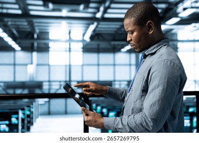 Admin in data center using tablet to deploy new server architectures, configuring network virtualization. Man in server room updating storage arrays, verifying settings to maintain stable performance
